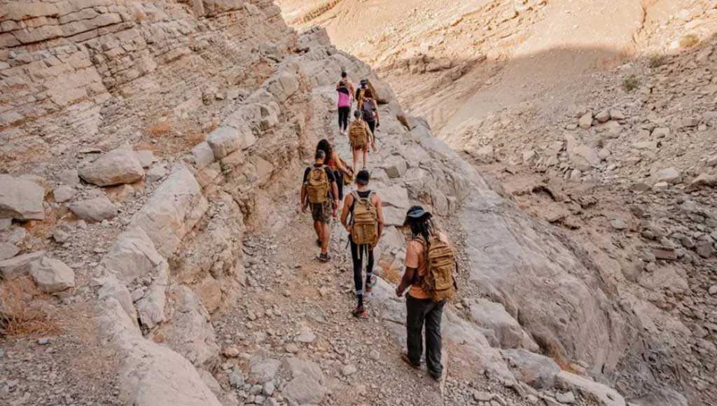 People walking a trail in the mountains - Camp Adventures - camping in uae